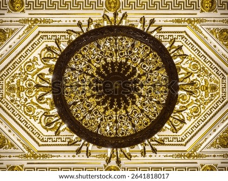 This direct overhead, wide-angle shot captures the stunning, richly detailed ceiling of the Hermitage Museum, likely within the historic Winter Palace in Saint Petersburg, Russia. A magnificent