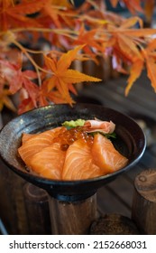 This is a donburi that called Salmon donburi. Include Fresh Salmon, hoba herb, wasabi, ginger. They put in the bowl on the table that have maple. It’s a Japanese food style.