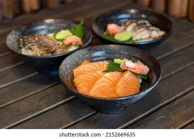 This is a donburi that called Salmon donburi. Include Fresh Salmon, hoba herb, wasabi, ginger. They put in the bowl on the table that have maple. It’s a Japanese food style.