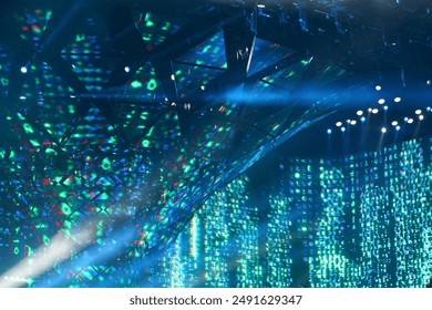 This dynamic image captures the vibrant atmosphere of a live concert or music festival. The stage is illuminated with bright, colorful lights and lasers, creating an electric ambiance.