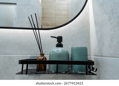 This elegantly designed bathroom features a sleek mirror, a decorative reed diffuser, and a modern soap dispenser on a minimalist shelf, creating a relaxing oasis for wellness and tranquility