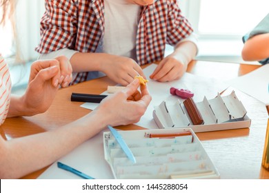 This is an example. Close up of a female hand with a plasticine toy being shown to a cute nice boy like an example