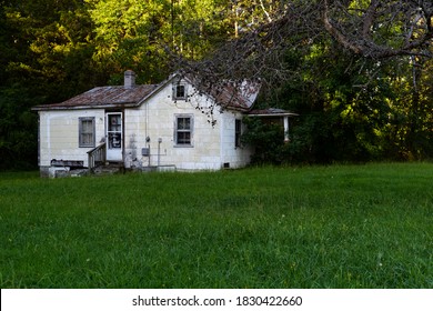 This is an exterior view of an abandoned white painted house in rural Virginia.