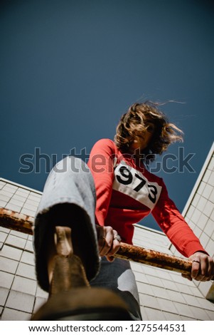 This is a fashion portrait of a woman. Her outfit has an older vibe and that compliments the washed look of these photos. A sunny day. 