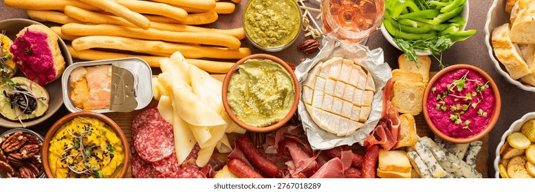 This festive spread features an array of cheese, cured meats, hummus, nuts, and fresh vegetables. Perfect for sharing at a casual get-together or celebration with friends, banner