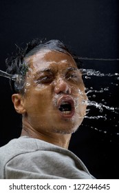 this file as face of asian man with splashing water on black background