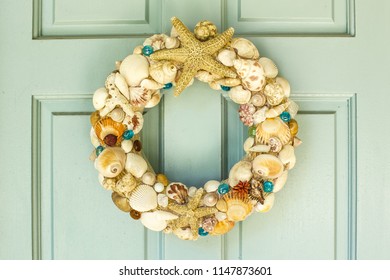 This is a front door  decor for summer with  starfishs , different of shells  ,Molluse shells,seashells,Paw shells, Banded shells and some of flowers and a little glass balls.