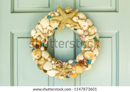 This is a front door  decor for summer with  starfishs , different of shells  ,Molluse shells,seashells,Paw shells, Banded shells and some of flowers and a little glass balls.