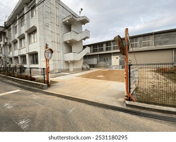This is a gate next to which there are two glass mirrors in a school building in Japan. 