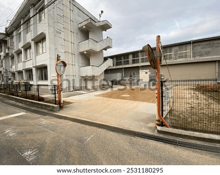 This is a gate next to which there are two glass mirrors in a school building in Japan. 