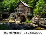 This is the Glade Creek Grist Mill located in Babcock State Park in West Virginia. This area is heavily forested with the Glade Creek running under the  bridge past the mill.