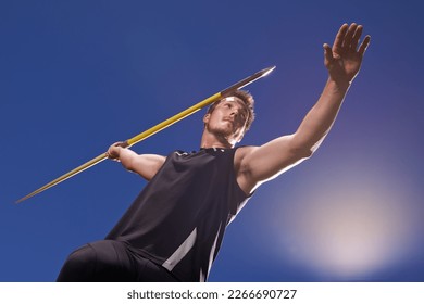 this is going the distance. Shot of a lone man throwing a javelin outside. - Powered by Shutterstock