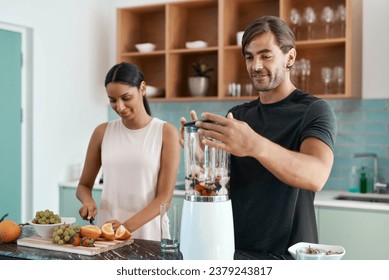 This is gonna taste amazing. Cropped shot of an affectionate young couple making smoothies in their kitchen at home. - Powered by Shutterstock