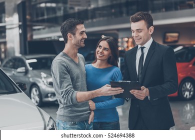 This is good choice. Confident young salesman making deal with young couple