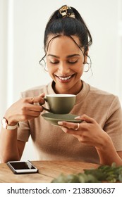 This Good Mood Was Sponsored By Coffee. Cropped Shot Of An Attractive Young Woman Sitting Alone In Her Home And Enjoying A Cup Of Coffee.