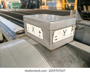 This is a grey, rectangular industrial control box with labels indicating X and Y axes, likely part of a machine or automation system.