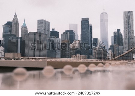 This gritty urban perspective offers a unique view of New York City's skyline from the Brooklyn Bridge, highlighting the city's architectural diversity and density.