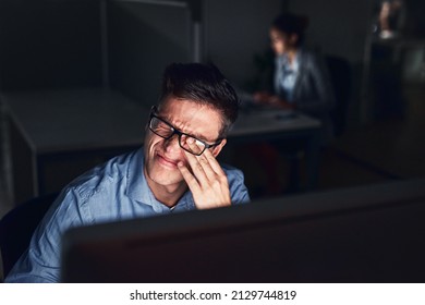 This Headache Is Not Helping My Productivity. Shot Of A Young Businessman Working Late At Night In A Modern Office.