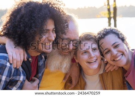 This heartwarming image captures a close-knit group of friends sharing a laugh together. The composition includes a diverse mix of individuals, including a young man with curly hair, an older man with