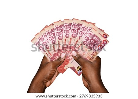 This high-angle, isolated shot features a pair of hands with deep skin tones holding a fanned-out stack of Ghanaian 200 Cedi banknotes against a clean white background. The notes, which are the highest denomination in Ghana, prominently display the 