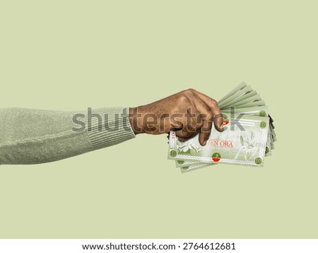 This high-angle, side-profile shot features a person’s arm and hand holding a fanned-out stack of Orania 