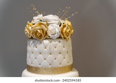 This high-resolution image features a three-tiered white wedding cake with gold trimming, perfect for adding a touch of elegance to special occasion