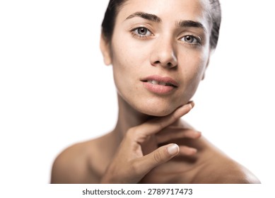 This high-resolution image features a young woman displaying natural beauty with minimal makeup in a studio environment, portraying confidence and serenity