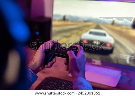 In this high-resolution image, a focused millennial guy is deeply engrossed in his gaming experience at home, potentially hinting at gaming addiction