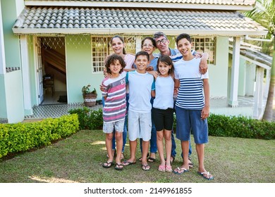 This House Has Built Three Generations Of Family Memories. Portrait Of A Happy Multi Generational Family Standing Together In Their Backyard.