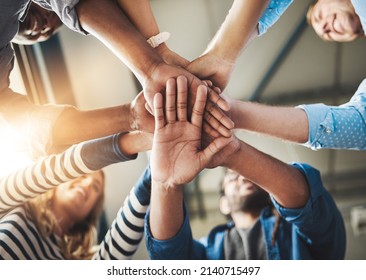 This is how it gets done. Shot of a group of creative businesspeople standing with their hands in a huddle. - Shutterstock ID 2140715497