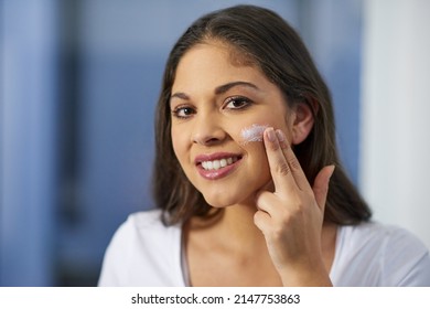 This Is How I Keep My Skin Soft And Supple. Shot Of An Attractive Young Woman Getting Ready In Her Bathroom.