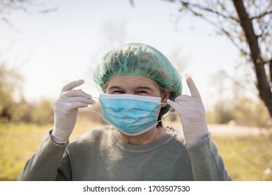 This Is How I Protect Myself From The Virus Corona. Senior Woman At Nature Wearing Face Mask And Medical Cap. Close Up.