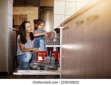 This is how we stack the dishwasher. Shot of a cute little girl and her mother loading the dishwasher together at home. - Powered by Shutterstock