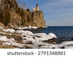 This is the iconic 1910 Split Rock Lighthouse on Lake Superior near Two Harbors, Minnesota in the middle of winter. A magnificent lighthouse completed in 1910 in a spectacular setting enhanced by lots of ice and white snow.  It was built to protect ships from the treacherous rocky coast after the devastating Mataafa Storm of 1905 that wreaked havoc and wrecked nearly 30 ships along Lake Superior
