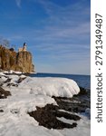 This is the iconic 1910 Split Rock Lighthouse on Lake Superior near Two Harbors, Minnesota in the middle of winter. A magnificent lighthouse completed in 1910 in a spectacular setting enhanced by lots of ice and white snow.  It was built to protect ships from the treacherous rocky coast after the devastating Mataafa Storm of 1905 that wrecked nearly 30 ships along Lake Superior