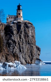 This is the iconic 1910 Split Rock Lighthouse on Lake Superior near Two Harbors, Minnesota in the middle of winter. A magnificent lighthouse completed in 1910 in a spectacular setting enhanced by lots of ice and white snow.  It was built to protect ships from the treacherous rocky coast after the devastating Mataafa Storm of 1905 that wrecked nearly 30 ships along Lake Superior's rocky coastline. There were no roads there at the time and 310 tons of materials were hoisted up the 133 foot sheer cliff from supply boats. The 133 foot shear cliff  the lighthouse sits on is most dramatic viewed from the lower lake shore area. Hiking here in winter can be a little treacherous with very large, rough rocks covered in thick ice and snow with the open lake waters right at the edge of the treacherous shore.
