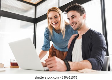 This Idea Is Great. Hilarious Colleagues Are Looking At Screen Of Laptop With Bright Smile