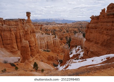 This image of Bryce Canyon features snow-covered red rock hoodoos standing tall under a clear sky. Contrast between the white snow and the vibrant orange rock formations.                     - Powered by Shutterstock