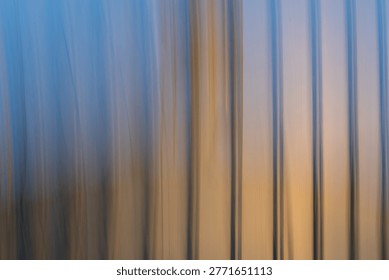 This image is a captivating example of Intentional Camera Movement (ICM) photography, featuring a series of vertical, blurred lines that create a rhythmic, painterly effect. The color palette transitions beautifully from a cool, ethereal twilight blue at the top to a warm, glowing amber and gold at the base. The soft, streaked textures evoke a sense of fluid motion and abstract tranquility, blurring the line between photography and contemporary digital art. The vertical flow and soft focus create a calming, Zen-like quality. The minimalist composition and elegant color gradient feel modern and high-end. The abstraction hides the original subject, inviting the viewer to interpret the forms as anything from a forest at dusk to light reflecting off water. Perfect as large-scale wall art for modern offices, spas, or minimalist living spaces to promote a calm environment. An ideal hero background for websites focusing on wellness, technology, or creative portfolios where text needs to be overlaid. A striking cover or background for magazines discussing mental health, philosophy, or abstract art. A sophisticated background for high-end skincare or organic product labels.