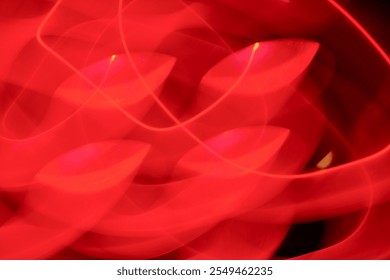 This image captures abstract red light trails forming intricate, circular patterns on a dark background with a red gradient, creating a dynamic visual effect. - Powered by Shutterstock - Get 15% off with code: PIKWIZARD15