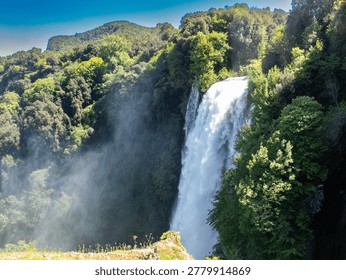 This image captures the breathtaking Cascata delle Marmore, one of the tallest waterfalls in Italy. Nestled in a lush natural setting, the waterfall cascades dramatically over rocky cliffs, creating a stunning display of rushing water and mist. Surrounded by verdant greenery, this picturesque location is a popular destination for nature lovers and photographers alike. Ideal for themes related to travel, nature, and outdoor adventures, this image showcases the beauty and power of one of Italy's natural wonders.