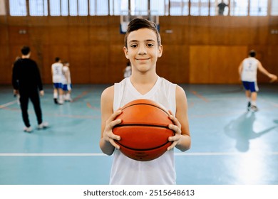 This image captures a cheerful kid holding a basketball, ready to play, encapsulating the joy and enthusiasm of sport - Powered by Shutterstock