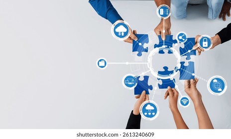 This image captures the essence of collaboration in computing, showcasing diverse hands assembling puzzle pieces with cloud technology icons in a modern workspace setting. Amity