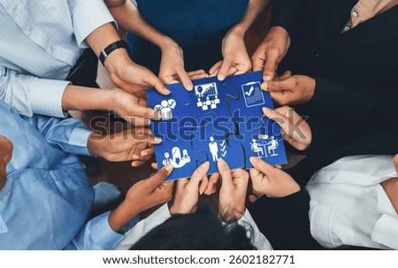 This image captures the essence of collaboration and management as hands come together to connect puzzle pieces, symbolizing teamwork and strategic business development. Amity
