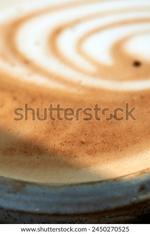 This image captures the essence of a barista’s skill, featuring a close-up of a creamy swirl atop a freshly brewed cappuccino