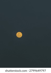 This image captures a full moon against a deep black night sky, creating a minimalist and serene composition. The moon is the sole focal point, emphasizing its beauty, brightness, and presence.