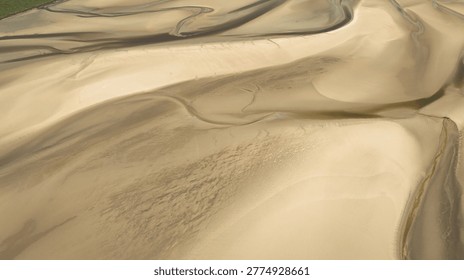 This image captures the intricate patterns of sand and water from an elevated perspective
