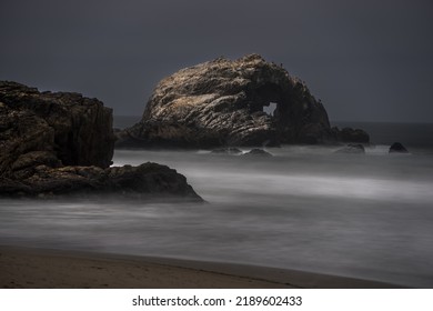 This Image Captures A Moody Ocean Landscape With Mist Rolling In Over The Water.