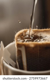 This image captures the precise moment of manual coffee brewing using the drip bag method.