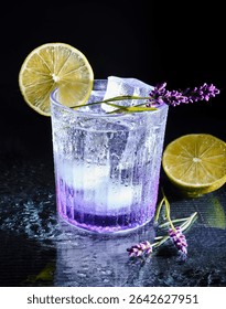 This image captures a refreshing and elegant lavender cocktail served in a textured glass with ice cubes. The drink shows a beautiful gradient from deep violet at the base .
